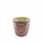 3D printed ceramic coffee mug with ripple texture and green glazed interior from the Migration of Matter collection